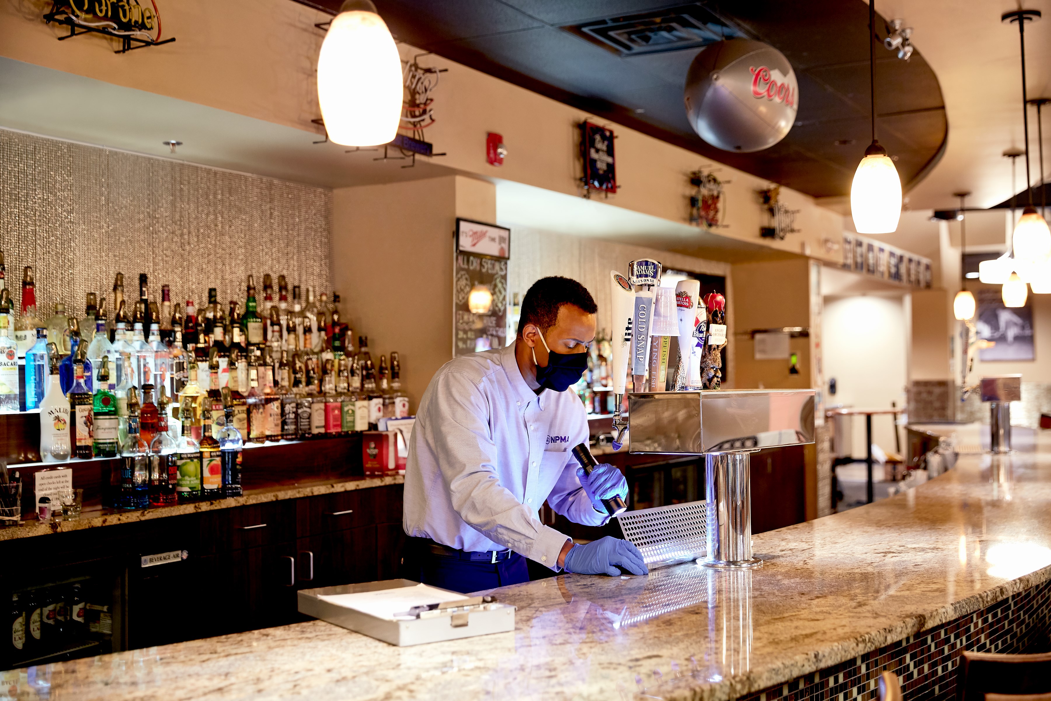 A pest control specialist inspecting a draft beer system